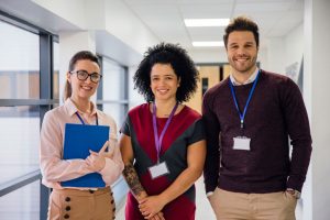 Three teachers standing in a hallway smiling